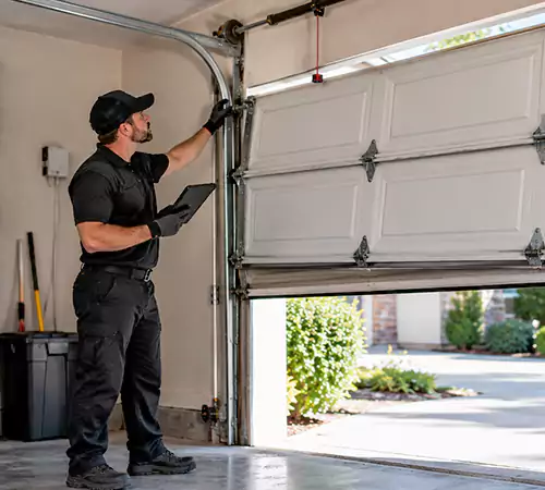 Technician performing an emergency garage door damage assessment in Indianapolis
