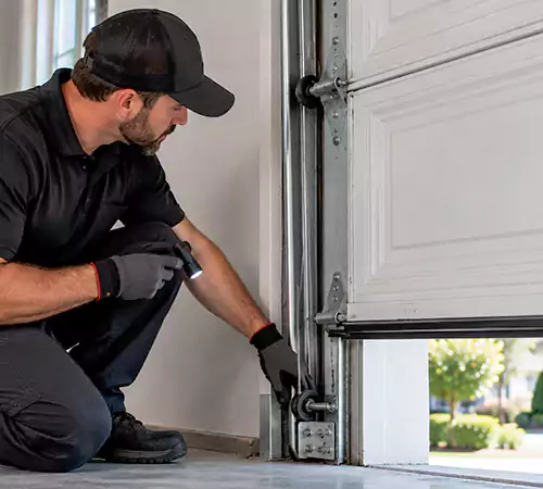 Technician inspecting garage door cable and lifting hardware in Indianapolis